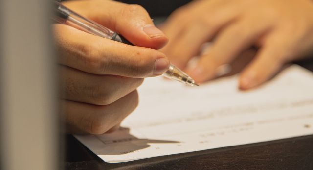 Man writing with pen on paper